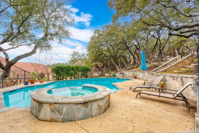 view of pool with an in ground hot tub