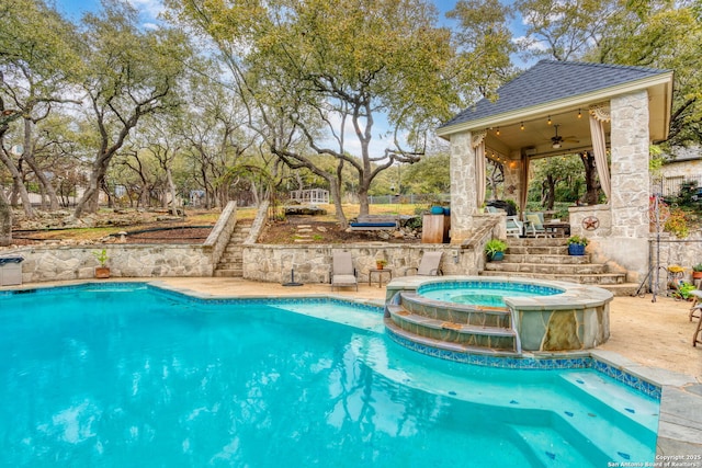 view of pool with a patio area, ceiling fan, and an in ground hot tub