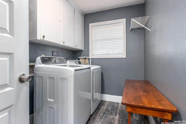 washroom featuring dark wood-type flooring, cabinets, and separate washer and dryer