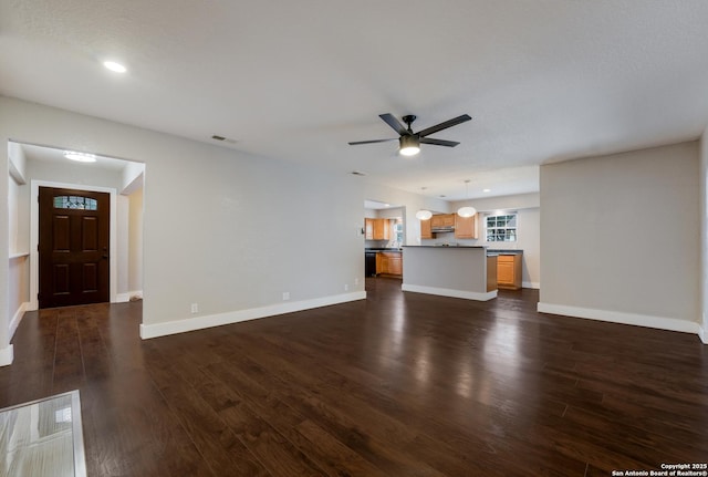 unfurnished living room with ceiling fan and dark hardwood / wood-style floors