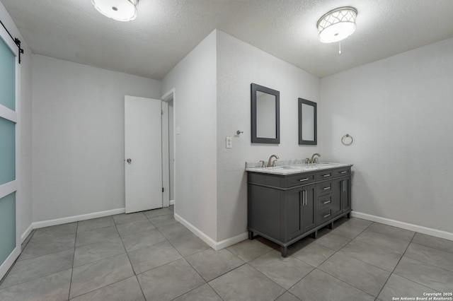 bathroom with tile patterned floors, vanity, and a textured ceiling