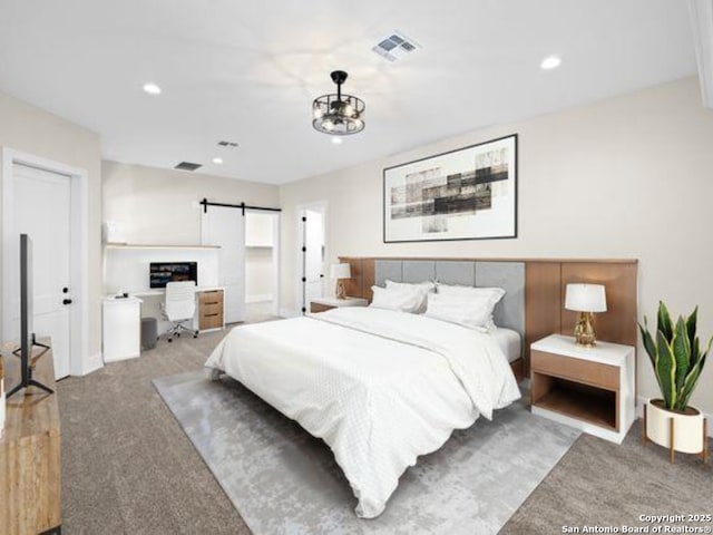 carpeted bedroom featuring a barn door