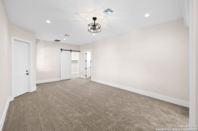 interior space with a barn door and light carpet