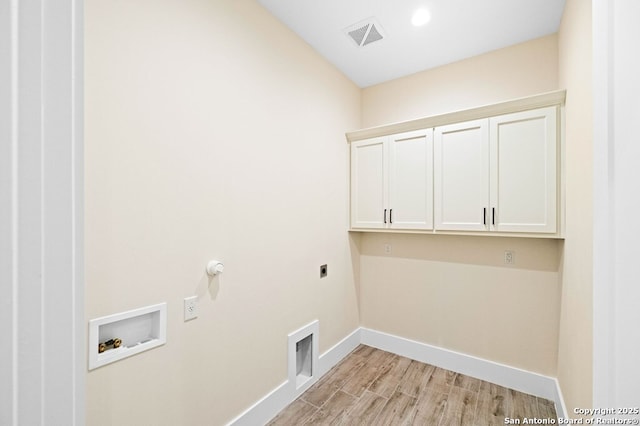 clothes washing area featuring gas dryer hookup, electric dryer hookup, cabinets, washer hookup, and light hardwood / wood-style floors