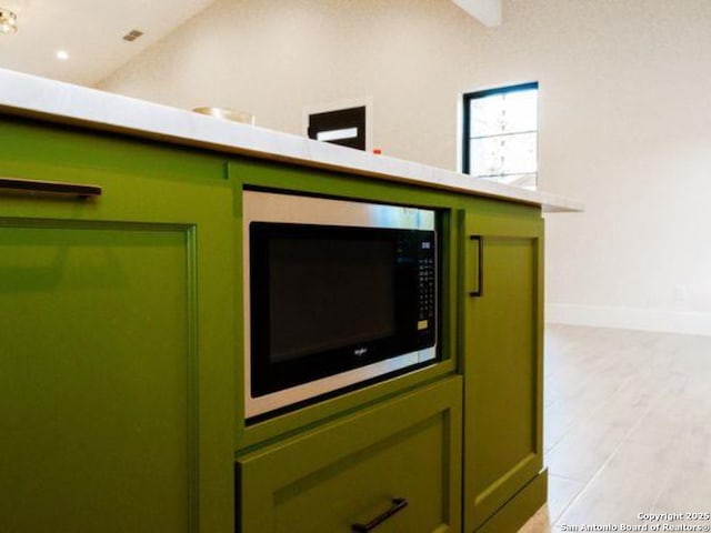 details featuring green cabinets and light hardwood / wood-style flooring