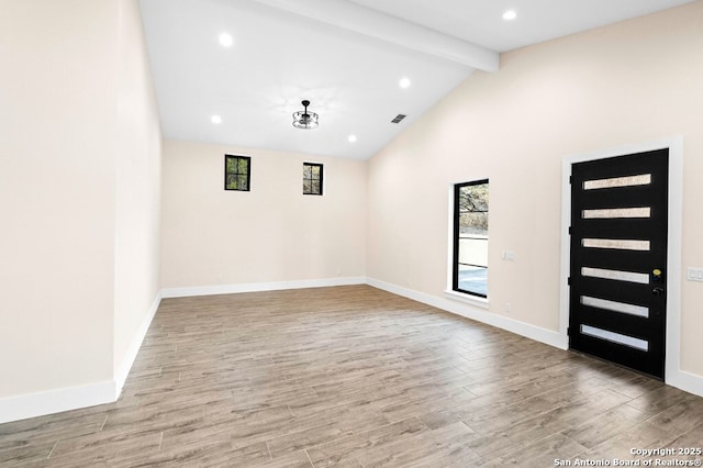 interior space with lofted ceiling with beams and light hardwood / wood-style floors