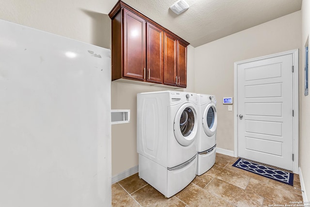 laundry room featuring cabinets, separate washer and dryer, and a textured ceiling