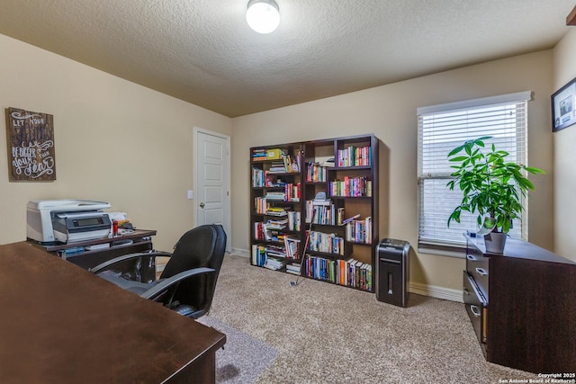 carpeted office space featuring a textured ceiling