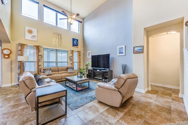 living room with ceiling fan and a high ceiling