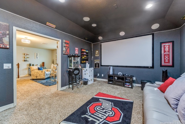 carpeted home theater room featuring vaulted ceiling