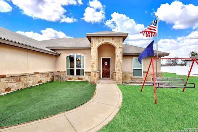 view of exterior entry with a lawn