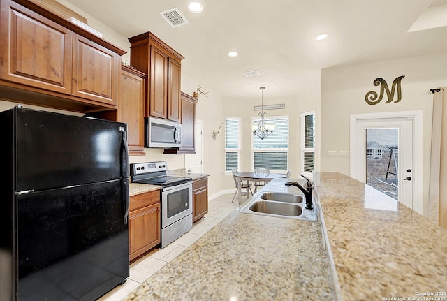 kitchen with appliances with stainless steel finishes, decorative light fixtures, sink, light tile patterned floors, and a notable chandelier