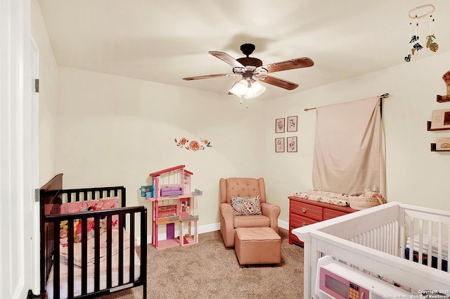 bedroom featuring ceiling fan, light carpet, and a crib