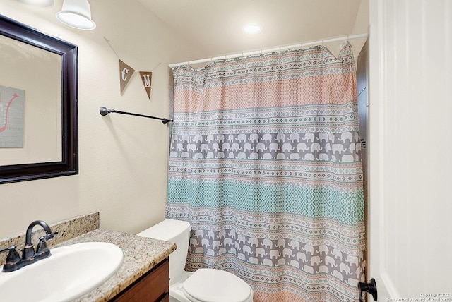 bathroom with walk in shower, vanity, and toilet