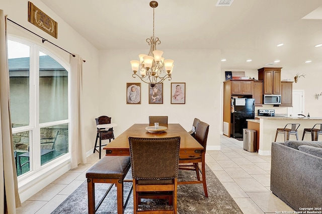 dining area with a chandelier and light tile patterned floors