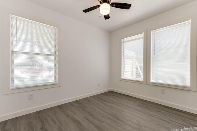 empty room with dark wood-type flooring and ceiling fan