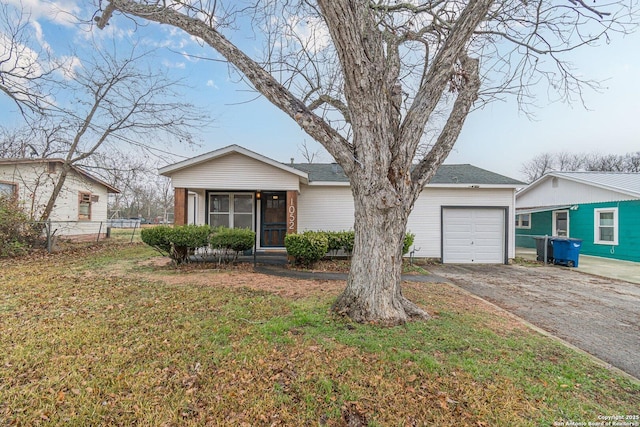 ranch-style house featuring a garage, a sunroom, and a front lawn