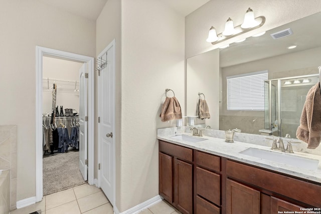 bathroom featuring a shower with door, vanity, and tile patterned flooring