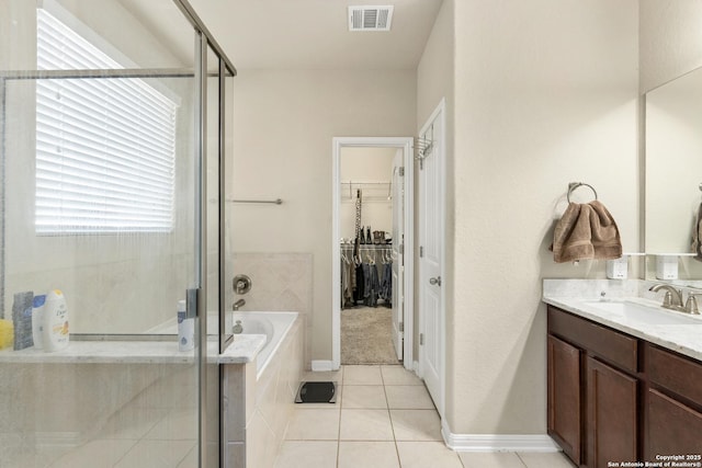 bathroom featuring tile patterned flooring, plus walk in shower, and vanity