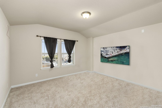 empty room featuring vaulted ceiling and light carpet