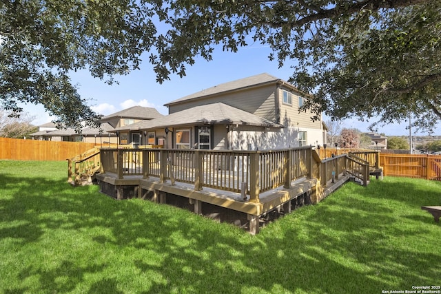 back of property featuring a deck and a lawn