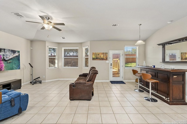 living room with vaulted ceiling, indoor bar, light tile patterned floors, and ceiling fan