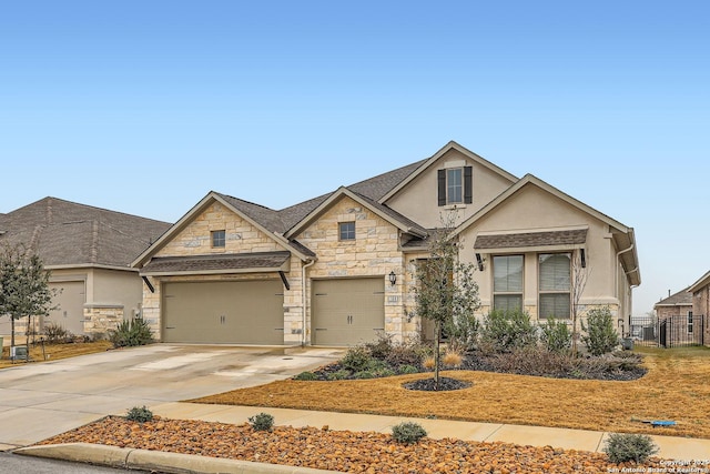 view of front of home featuring stone siding, stucco siding, concrete driveway, and fence