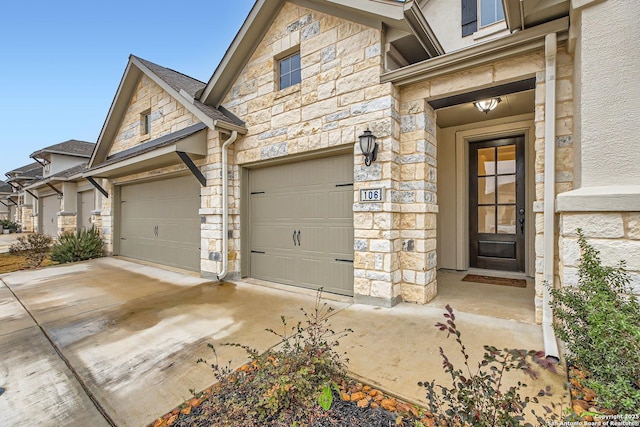 exterior space with stone siding, stucco siding, and an attached garage