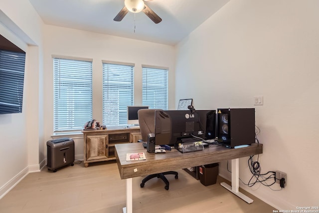 home office with plenty of natural light, ceiling fan, and light hardwood / wood-style flooring