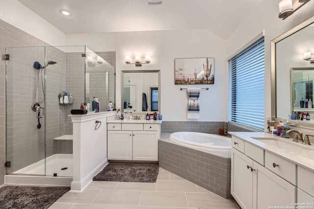 bathroom with tile patterned flooring, shower with separate bathtub, lofted ceiling, and vanity