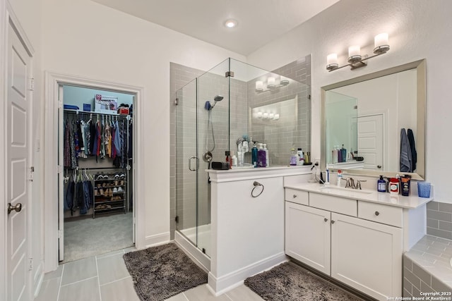 full bathroom with a spacious closet, tile patterned floors, a stall shower, and vanity