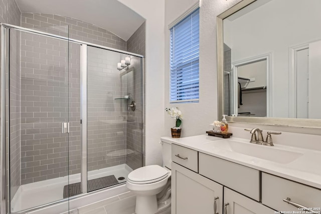 bathroom featuring an enclosed shower, vanity, and toilet