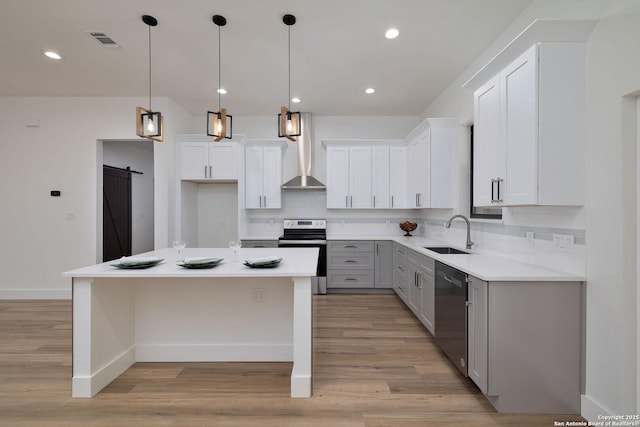 kitchen featuring sink, dishwasher, white cabinetry, stainless steel range with electric cooktop, and a barn door