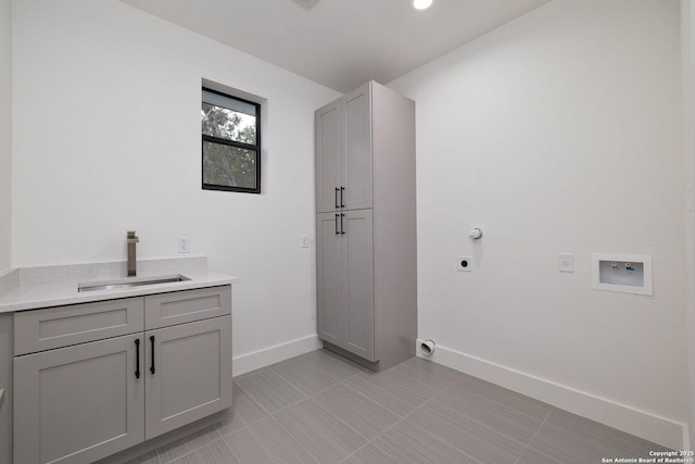 laundry room featuring sink, cabinets, light tile patterned floors, hookup for a washing machine, and hookup for an electric dryer