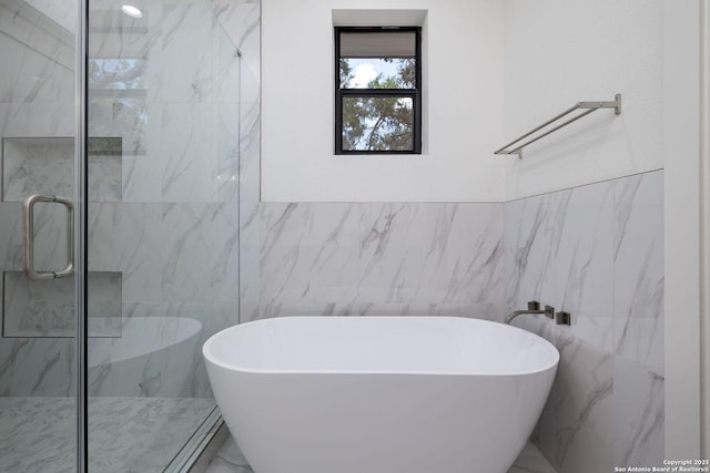 bathroom with separate shower and tub and tile walls