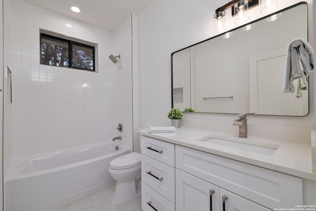 full bathroom featuring tiled shower / bath, vanity, and toilet