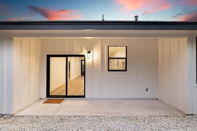 exterior entry at dusk with a patio area