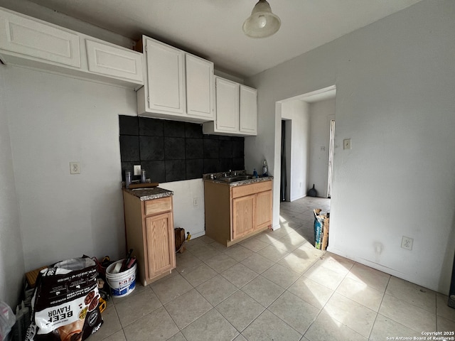 kitchen featuring sink, light tile patterned floors, white cabinets, and decorative backsplash