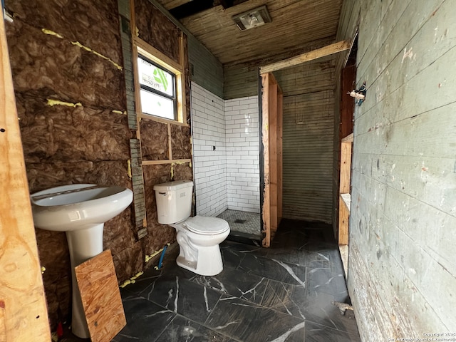 bathroom with toilet and tiled shower