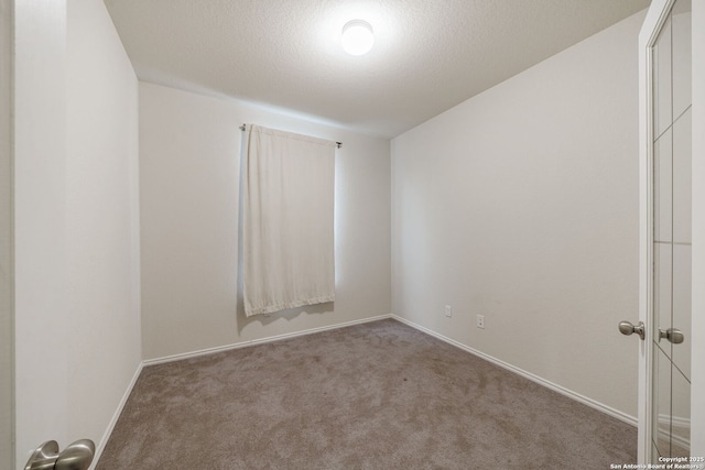 carpeted empty room featuring a textured ceiling