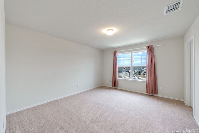 carpeted empty room with a textured ceiling