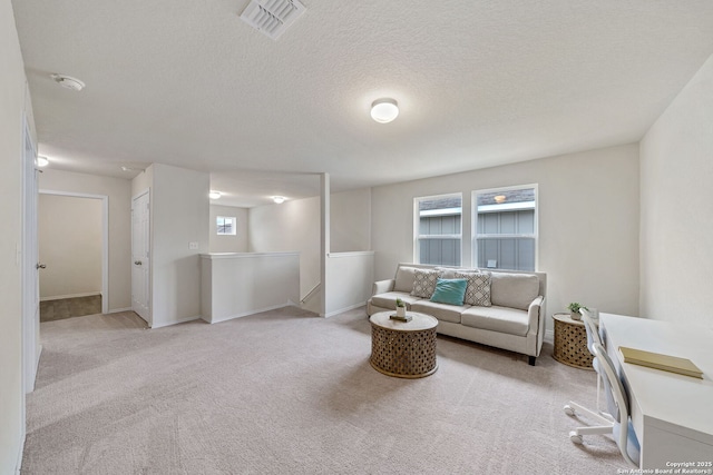 sitting room featuring light colored carpet and a textured ceiling