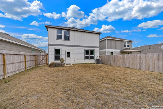 rear view of property featuring a yard and central air condition unit