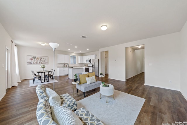 living room featuring a healthy amount of sunlight and dark hardwood / wood-style flooring