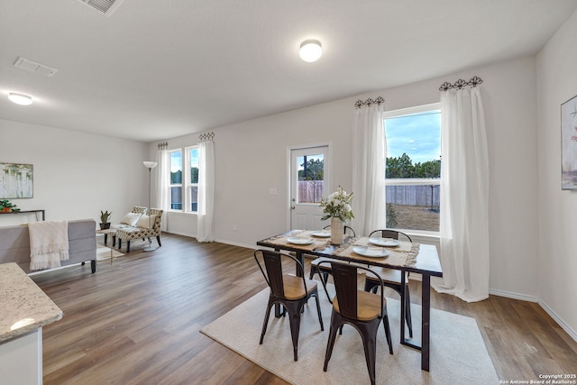 dining space featuring dark wood-type flooring and a wealth of natural light