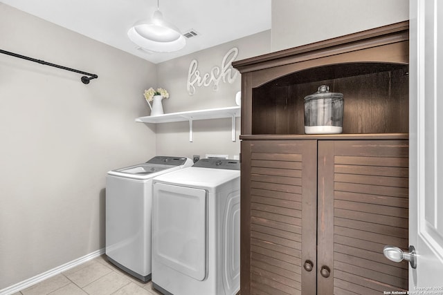 laundry area with washing machine and dryer and light tile patterned flooring