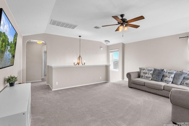 living room featuring lofted ceiling, carpet flooring, and ceiling fan with notable chandelier