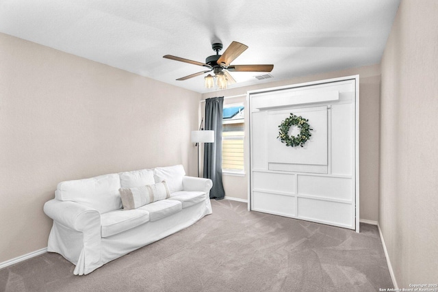 living area with ceiling fan and carpet floors