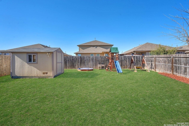 view of yard featuring a playground and a storage unit