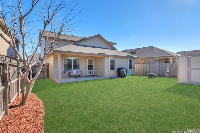 back of house with a yard, a patio area, and a storage unit